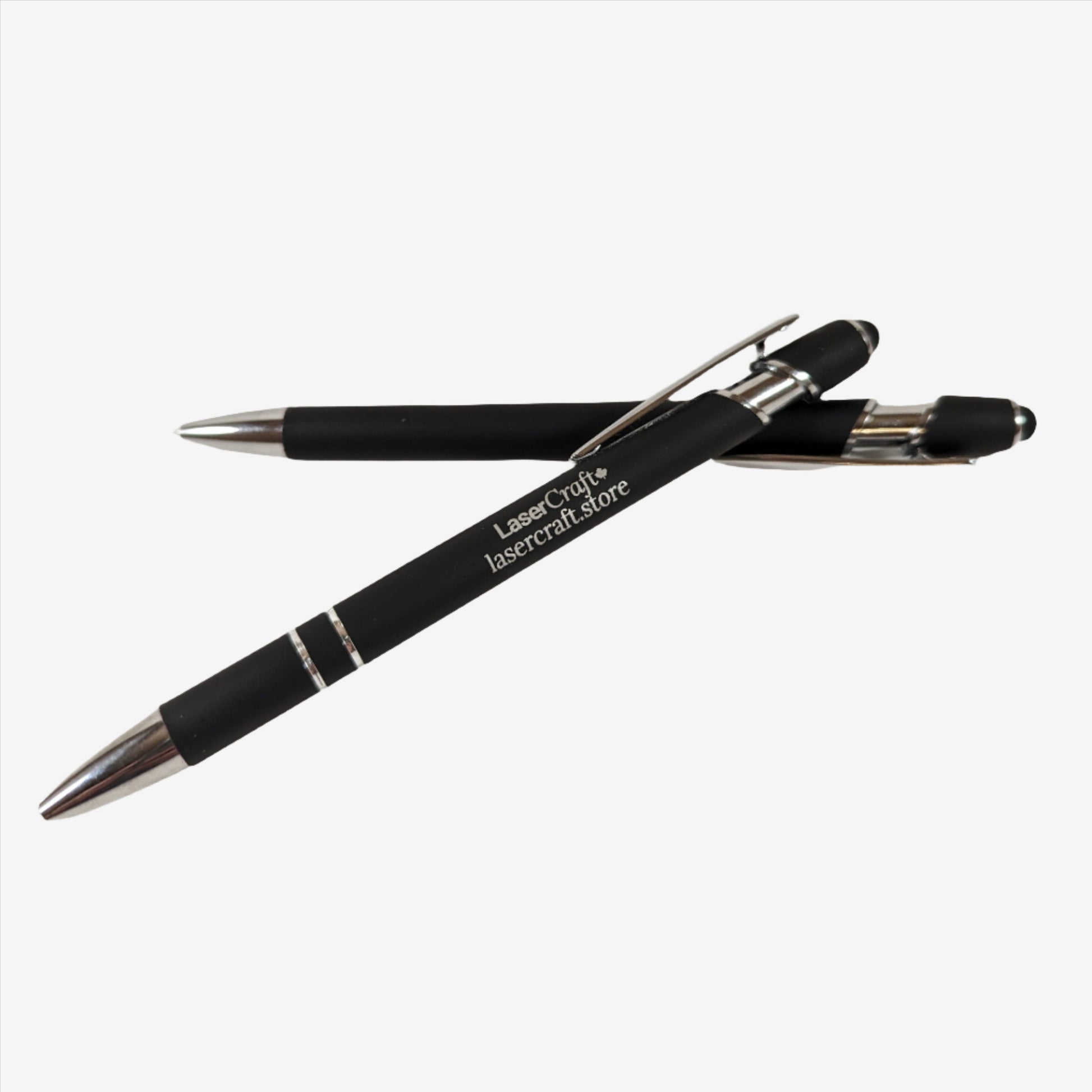 Two black pens with custom laser engraving displayed. The pens are sleek and elegant, featuring precise, silver-colored engravings along their barrels, showcasing the personalization option available.