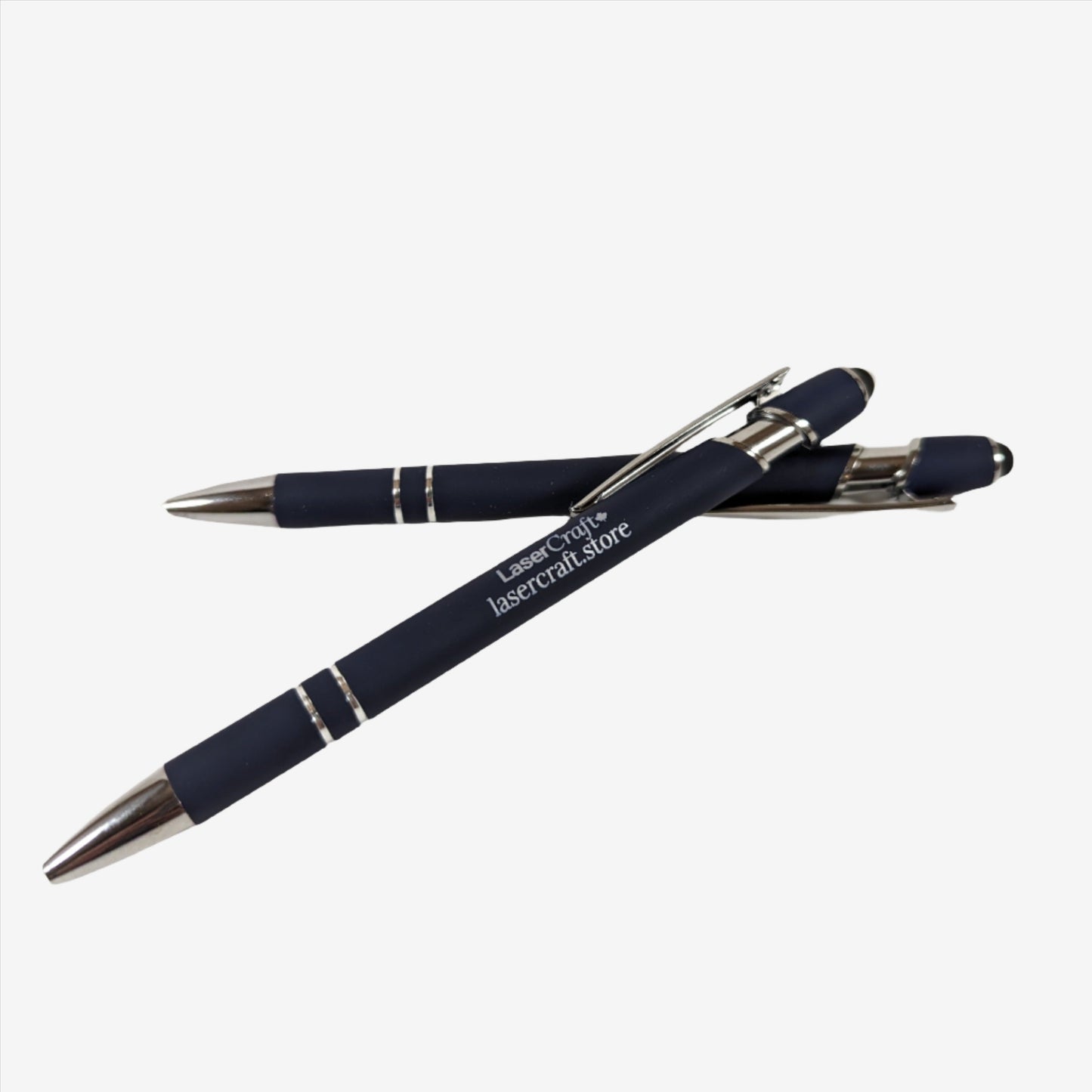 Two dark blue pens with custom laser engraving displayed. The pens are sleek and elegant, featuring precise, silver-colored engravings along their barrels, showcasing the personalization option available.