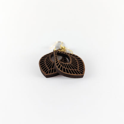 Handcrafted teak earrings featuring intricate laser-engraved designs, showcasing natural wood grain and artistic detailing. They feature a beautiful petal design.